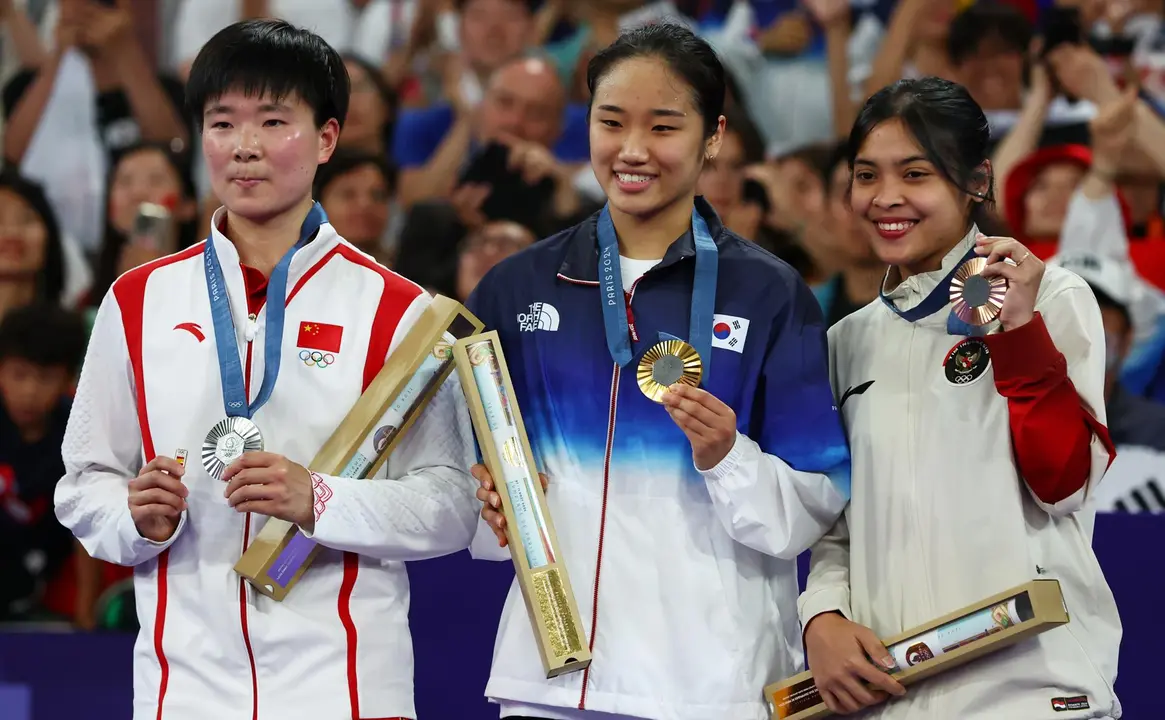 La china Bing Jiao He (iz) homenaje&oacute; a Carolina Mar&iacute;n posando en el podio con un pin de la delegaci&oacute;n espa&ntilde;ola en se&ntilde;al de cari&ntilde;o y apoyo. EFE/EPA/DIVYAKANT SOLANKI