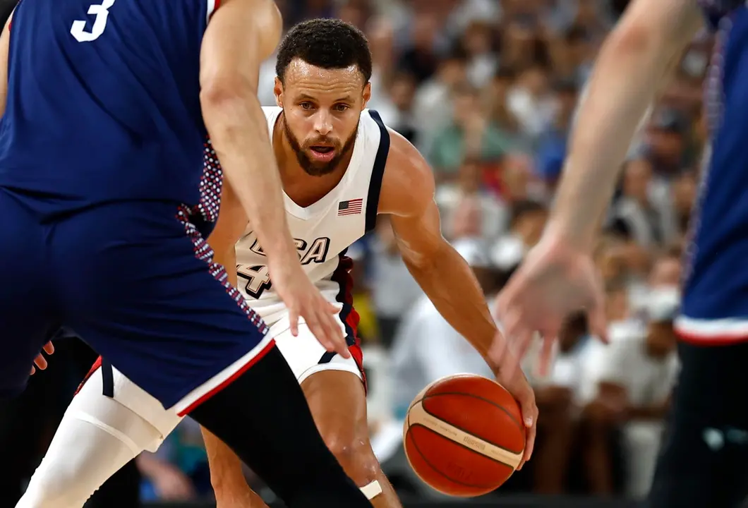 Stephen Curry (c), base de Estados Unidos, fue registrado este jueves, 8 de agosto, al intentar superar la marca de la defensa de Serbia, durante una de las semifinales del baloncesto de los Juegos Ol&iacute;mpicos 2024, en el coliseo South Par&iacute;s Arena de la capital francesa. EFE/Yoan Valat