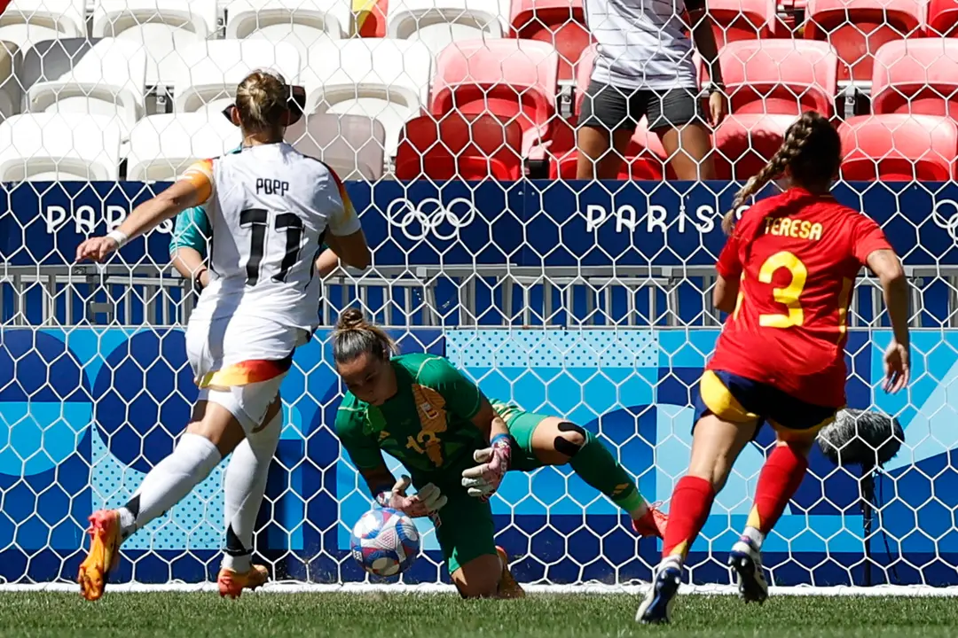 La portera espa&ntilde;ola Cata Coll para un disparo a puerta ante la alemana Alexandra Popp (i) durante el partido por el bronce. EFE/ Miguel To&ntilde;a