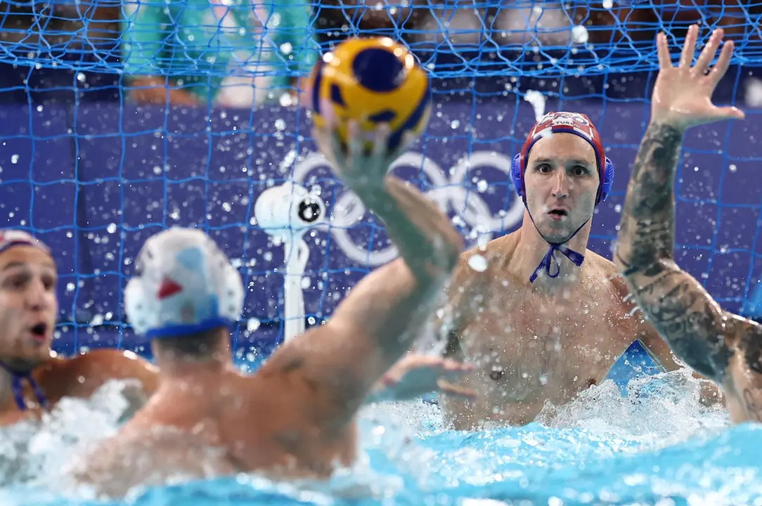 El portero croata Marko Bijac trata de detener un disparo de un jugador serbio, en la final de waterpolo en los Juegos Ol&iacute;mpicos de Par&iacute;s 2024 disputada en el Centro Acu&aacute;tico de Saint Denis. EFE/EPA/ANNA SZILAGYI