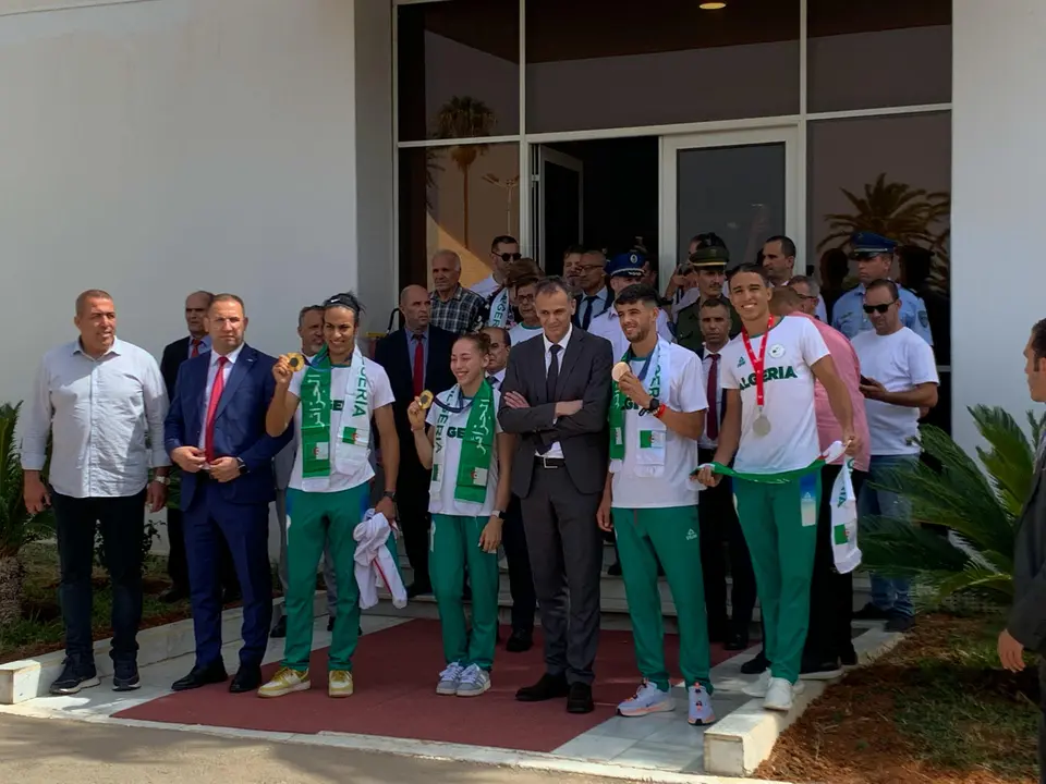 (izda a dcha) Imane Khelif, medalla de oro en boxeo femenino -66 kilogramos; Kaylia Nemour, oro en barras asim&eacute;tricas y Djamel Sjati, medallista de bronce ol&iacute;mpico en los 800 metros posan durante una recepci&oacute;n con el ministro argelino de Deportes, Abderrahmane Hammad, durante una  recepci&oacute;n en el aeropuerto de Argel de los medallistas ol&iacute;mpicos. EFE/ Laura Fern&aacute;ndez Palomo