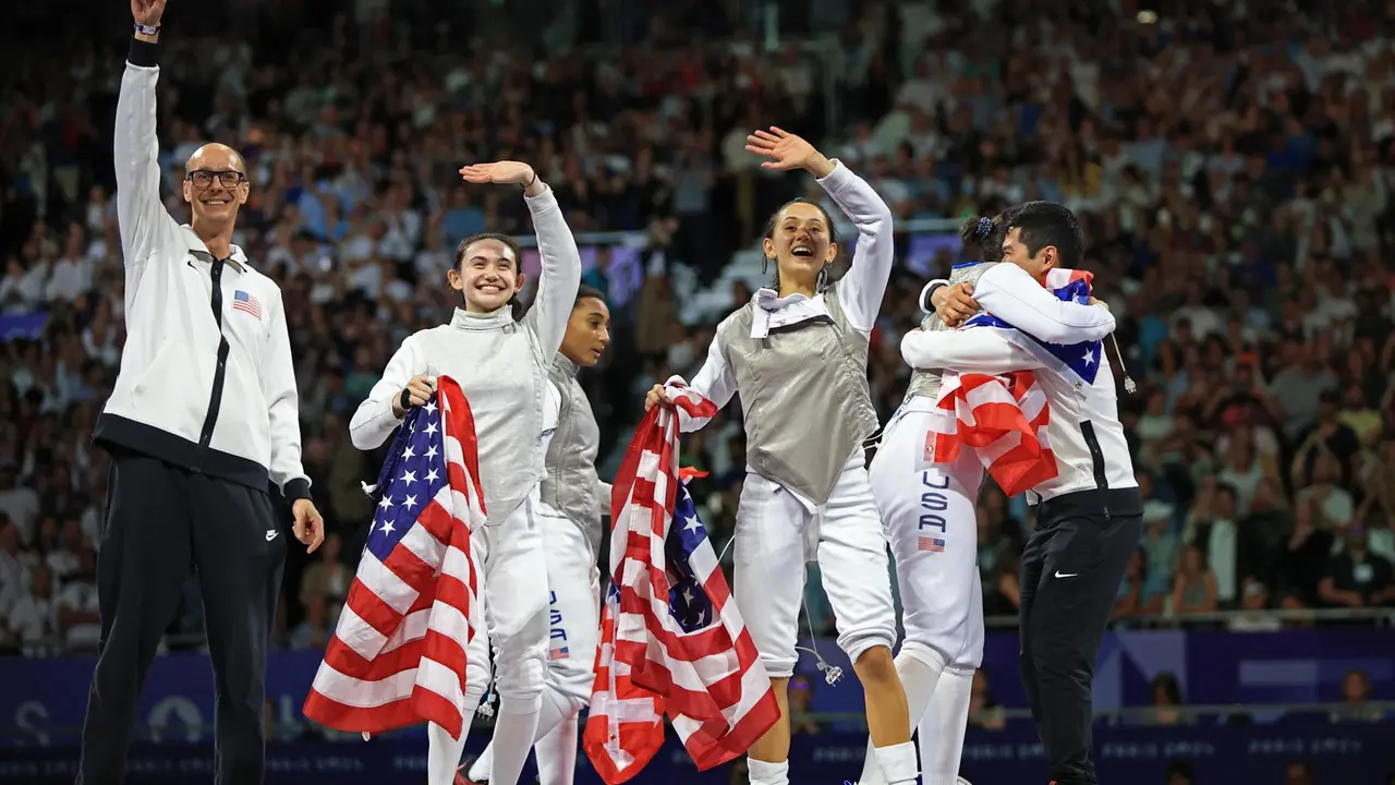Las estadounidenses Jacqueline Dubrovich, Lee Kiefer, Lauren Scruggs y Maia Mei Weintraubjunto a sus entrenadores celebran el oro conseguido en el Grand Palais in Paris, Francia. EFE/EPA/MARTIN DIVISEK