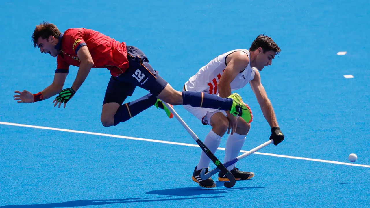 El jugador de la selecci&oacute;n espa&ntilde;ola masculina de Hockey Hierba Marc Reyne (L) cae ante el belga Thibeau Stockbroekx (R) durante el partido. EFE/Lavandeira Jr