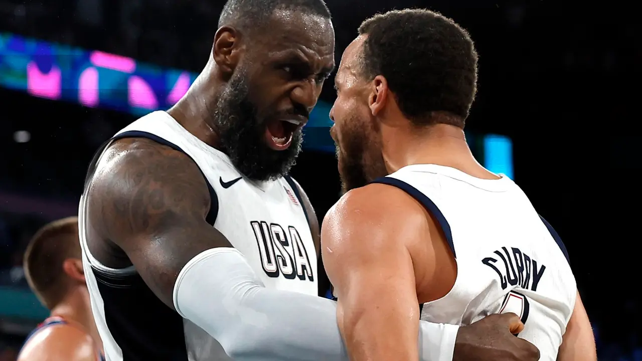 Los estadounidenses Lebron James (izq.) y Stephen Curry celebran la victoria en el partido de semifinales ante Serbia, del torneo de baloncesto de Par&iacute;s 2024. EFE/EPA/YOAN VALAT