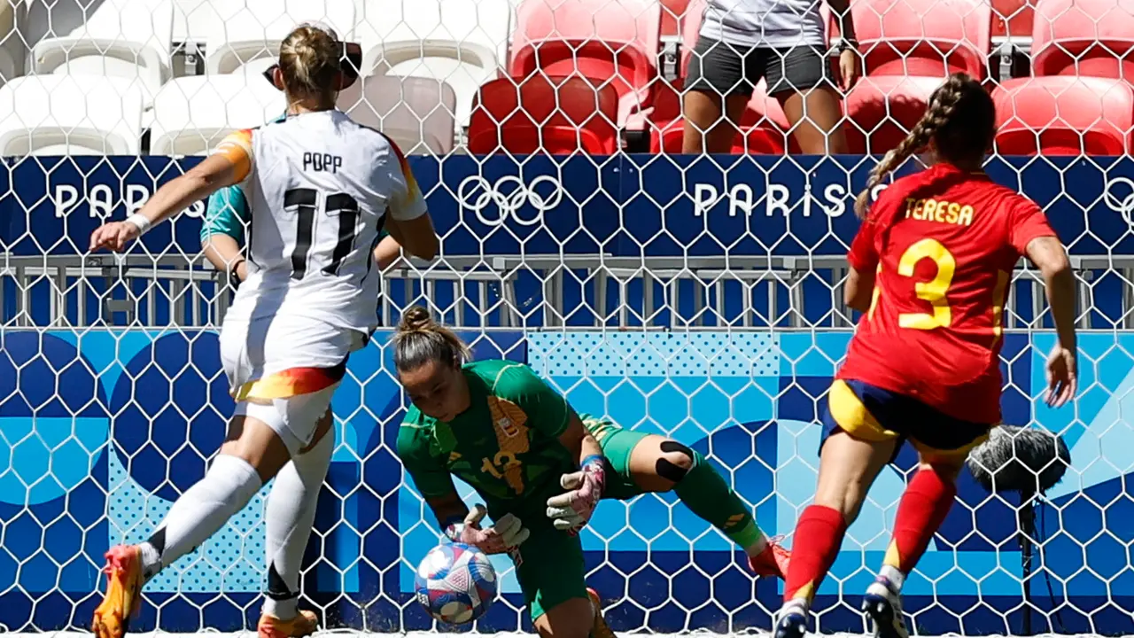 La portera espa&ntilde;ola Cata Coll para un disparo a puerta ante la alemana Alexandra Popp (i) durante el partido por el bronce. EFE/ Miguel To&ntilde;a