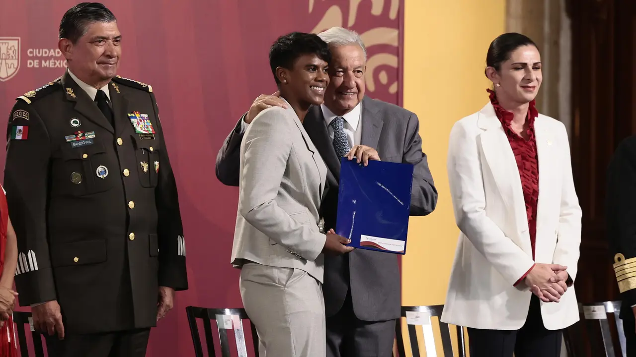 El presidente de M&eacute;xico, Andr&eacute;s Manuel L&oacute;pez Obrador (cd), entrega un est&iacute;mulo econ&oacute;mico a la judoka Prisca Awiti (ci), durante un acto celebrado este martes en Palacio Nacional de la Ciudad de M&eacute;xico (M&eacute;xico). EFE/Jos&eacute; M&eacute;ndez