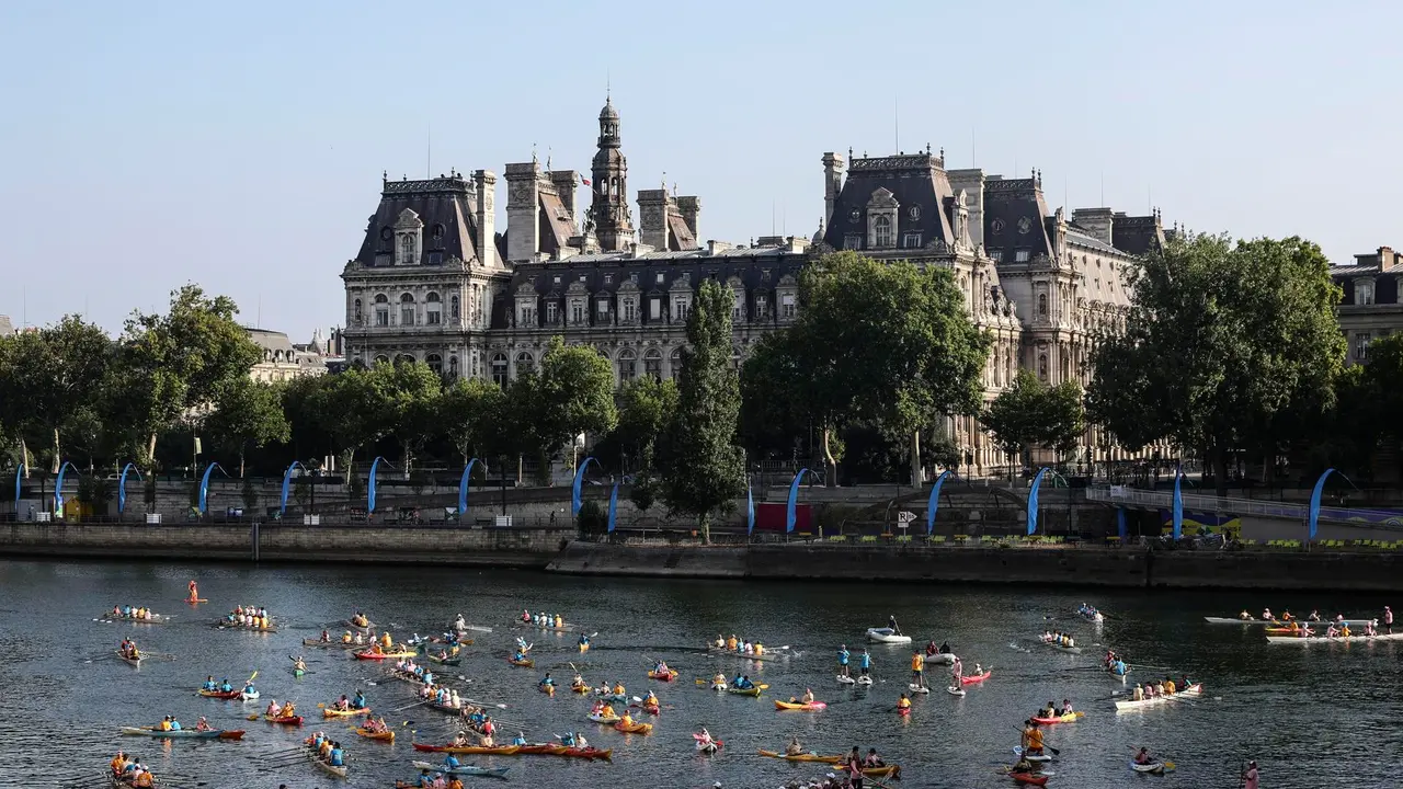 Participantes en el Festival del Sena pasan frente al Ayuntamiento de Par&iacute;s mientras navegan en kayak, reman y practican paddle surf por el r&iacute;o como parte de las celebraciones del primer aniversario de los Juegos Ol&iacute;mpicos de Par&iacute;s 2024. EFE/EPA/TERESA SUAREZ